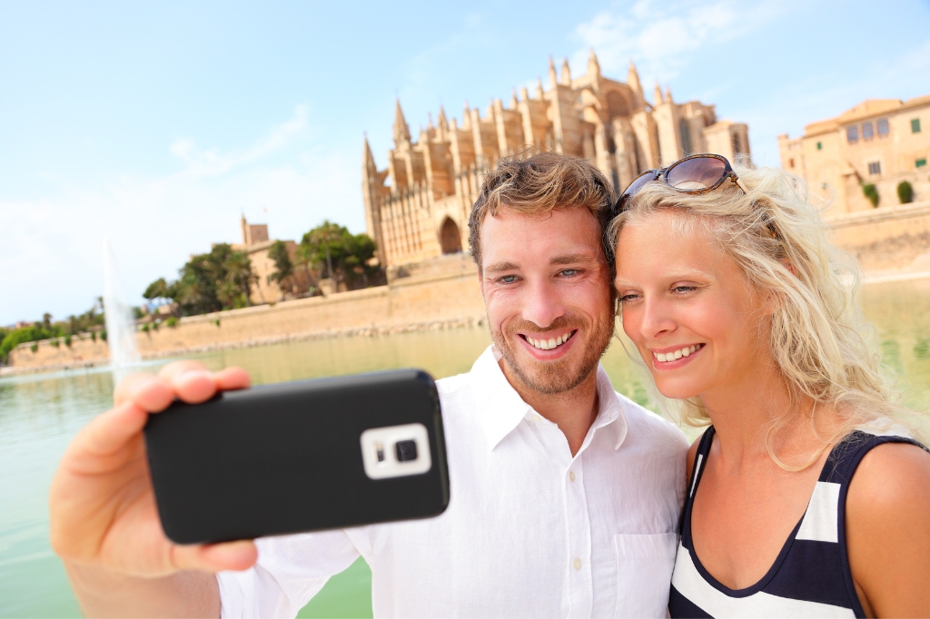 Happy couple take a selfie in front of Mallorca Cathedral